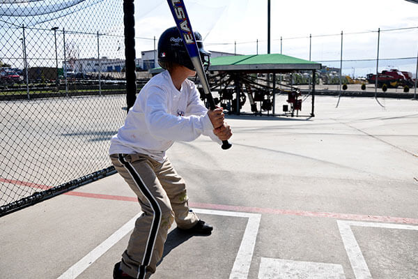 boy ready to hit in batting cage