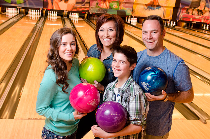 Family of four pose with bowling balls