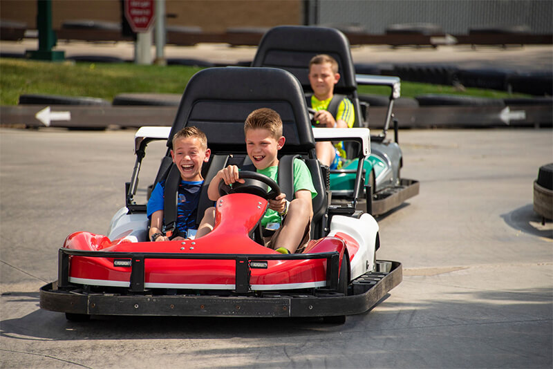 young children driving red go kart